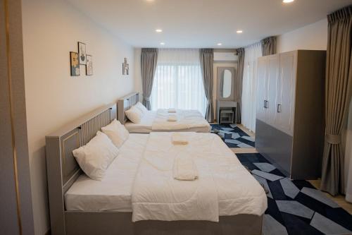 a bedroom with two beds with white sheets at Vera Cozy Stay 2 in Ban Zong Katiam