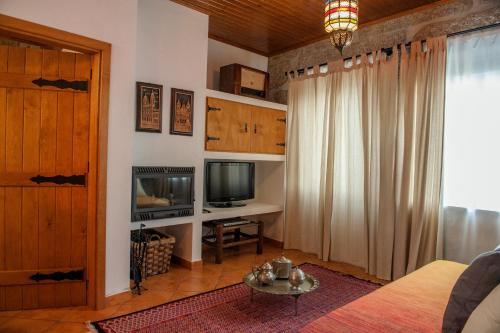 a living room with a couch and a television at Moinhos do Pisão in Povoa Dao