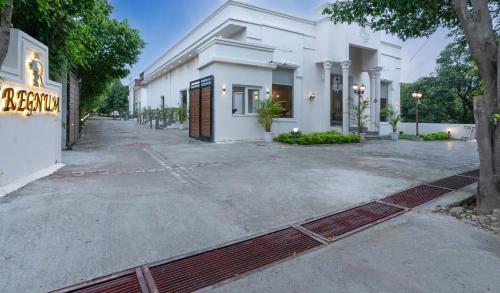 an empty street in front of a white building at Corbett The Regnum Resort in Rāmnagar