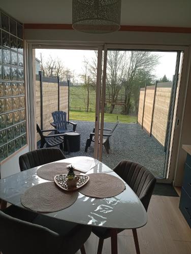 un tavolo e delle sedie in una stanza con un patio di Studio a Blosville