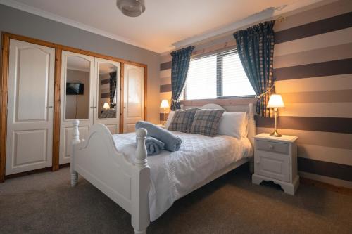 a bedroom with a white bed and a window at Wildeston in Thurso