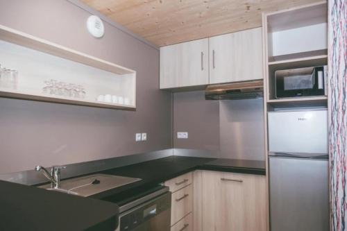 a kitchen with white cabinets and green counter tops at ZEcamping 3 étoiles animaux acceptés piscine et restaurant in Pluherlin