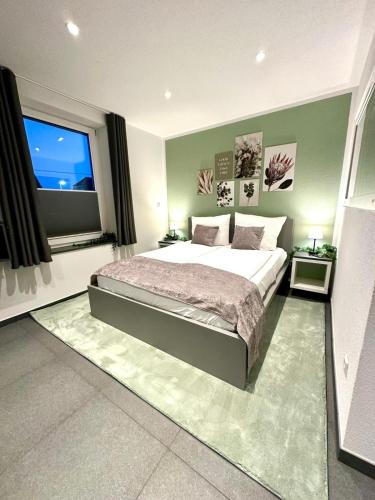 a bedroom with a large bed and a large window at LH Apartments Aulendorf in Aulendorf
