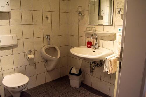 a bathroom with a sink and a toilet and a urinal at Ferienweingut Kreuz-Bauer in Minheim