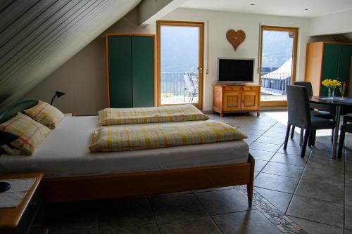 a bedroom with a bed and a desk and a television at Ferienweingut Kreuz-Bauer in Minheim