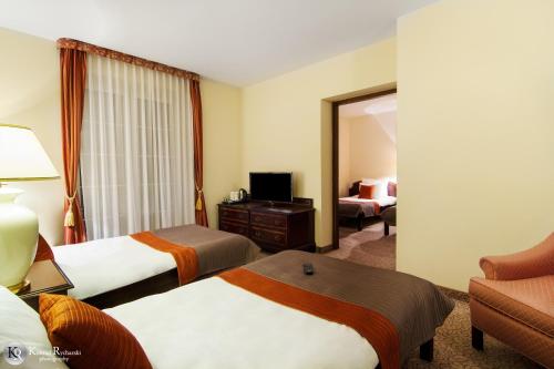 a hotel room with two beds and a mirror at Hotel Wisła Premium in Wisła
