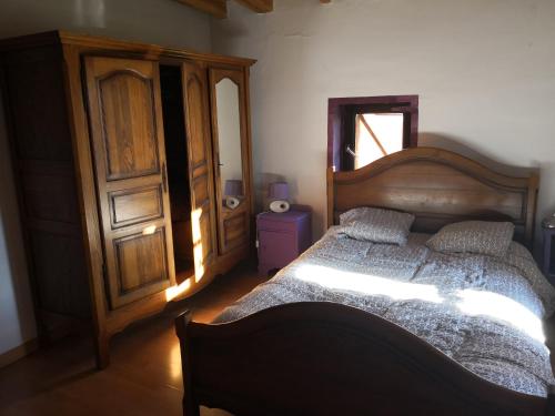 una camera da letto con un letto in legno e una cassettiera in legno di Casa Atuel a Bierge