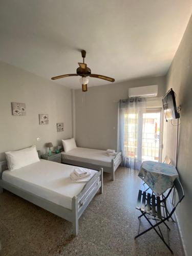 a bedroom with two beds and a ceiling fan at Studio Mytzela in Amaliapoli