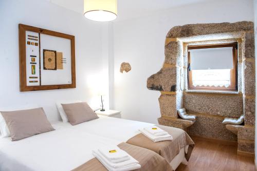 a small bedroom with a bed and a window at Moinhos do Pisão in Povoa Dao