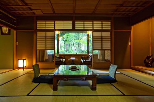a room with a table and chairs and a window at Ichirino Kogen Hotel Roan in Hakusan