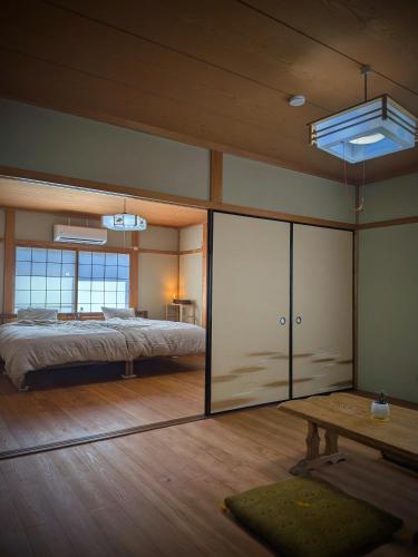 a large bedroom with a bed and a table at とまり木 in Yoshino