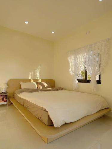 a bedroom with a large bed with a window at Hannie House- Mộc Châu in Mộc Châu