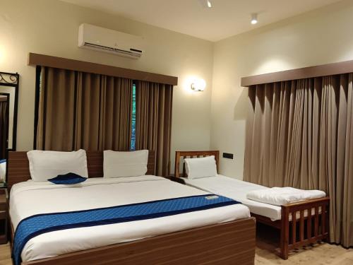 a hotel room with two beds and a window at Olive Resort & Villas in Khawāsa