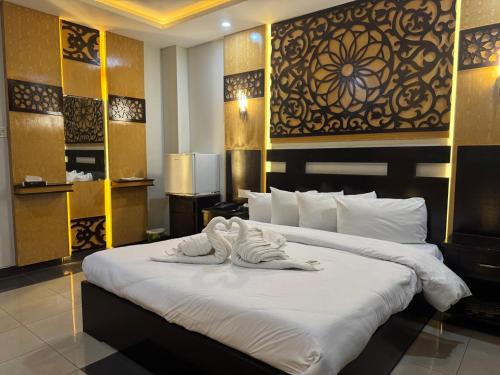 a hotel room with a bed with a towel on it at Crystal Crown Hotel in Peshawar