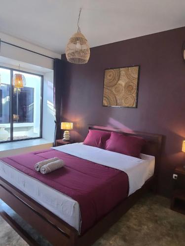 a bedroom with a large bed with red pillows at Stars Villa in Ngingas