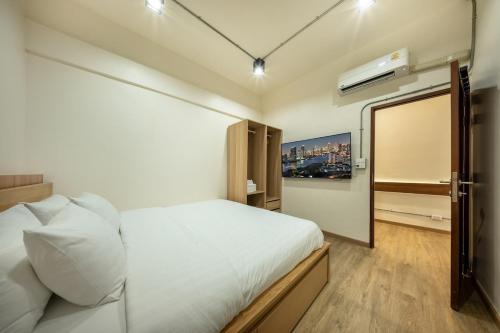 a bedroom with a white bed and a window at Swing By in Bangkok