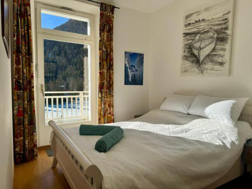 a bedroom with a large bed with a window at Vache Mystique in Orsières
