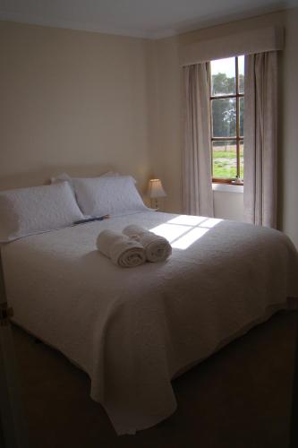 a bedroom with a white bed with towels on it at Buttons Cottage for September baby lambs in Nietta