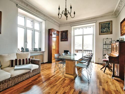 a living room with a table and a piano at Rottenhöfer Retreat Villa in Berchtesgaden