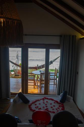 a bedroom with a view of a table and a balcony at Primaluna Romantica in La Punta de los Remedios