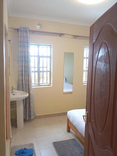 a bedroom with a bed and a sink and a window at Longonot View Camp and Accommodation, Naivasha in Naivasha