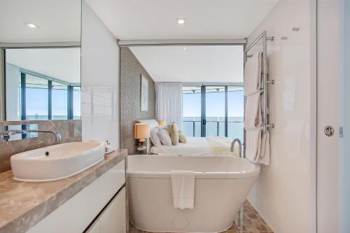 
a bathroom with a tub and a sink at Peppers Soul Surfers Paradise in Gold Coast
