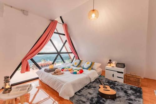 a bedroom with a bed with a large window at Mon Mon Homestay in Mon Jam