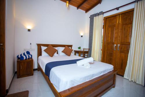 a bedroom with two beds and a door to a room at Palms shede Villa in Habaraduwa Central