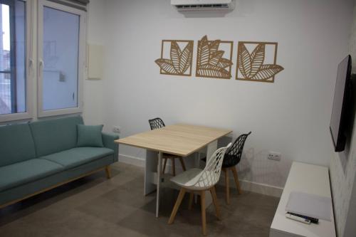 a living room with a table and chairs and a couch at Apartamentos Lumael in Mérida