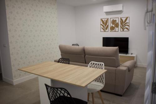 a living room with a table and a couch at Apartamentos Lumael in Mérida