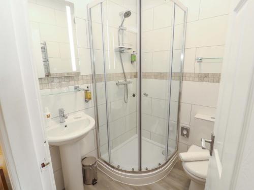 a bathroom with a shower and a sink and a toilet at 1 Park Road in Windermere