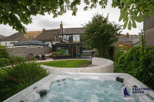 a hot tub in the backyard of a house at Chic Devon Designer Oasis with hot tub in Malborough