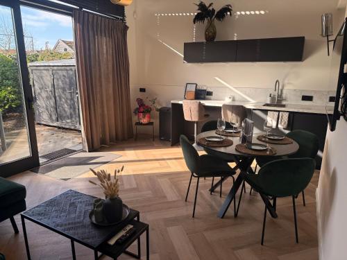 a kitchen and living room with a table and chairs at Cozy & Modern Tiny House in Velserbroek