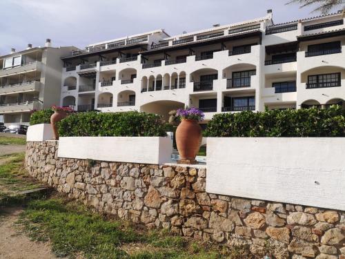 a stone wall with flower pots on it in front of a building at Anna in L'Escala