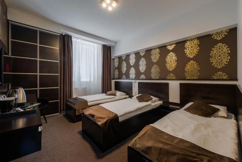 a hotel room with two beds and a window at Hotel Polo in Prešov