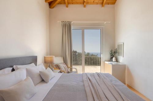 a bedroom with a bed and a sliding glass door at Magganos Sunset Villas in Fiskardo