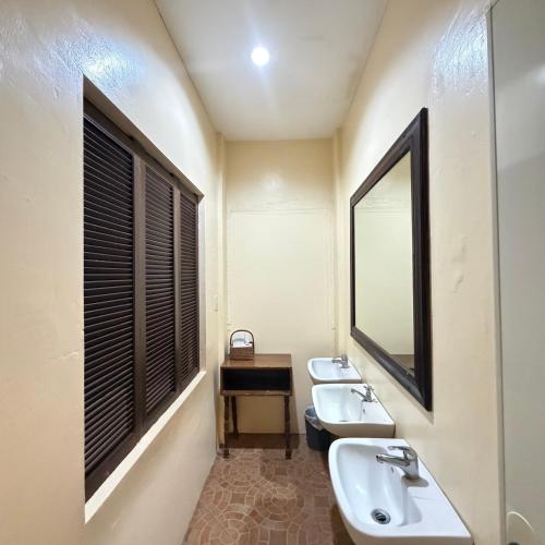 a bathroom with two sinks and a mirror at Sierra Resort in Dauin