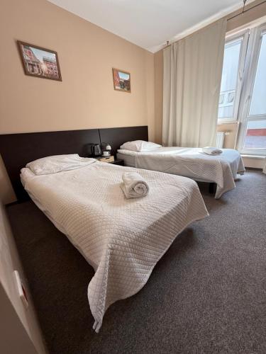 a hotel room with two beds and a window at Hotel Aqua Żyrardów in Żyrardów