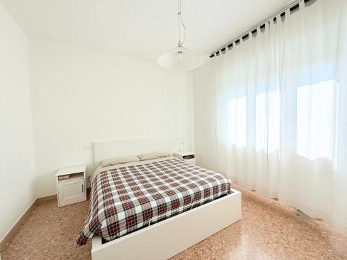 a white bedroom with a bed and a window at S357 - Sirolo, luminoso trilocale con posto auto in Sirolo