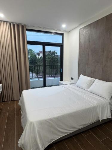a bedroom with a large white bed with a large window at Lighthouse Apartment in Ða Gia