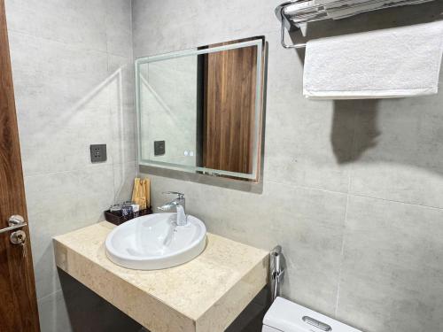 a bathroom with a sink and a mirror and a toilet at Lighthouse Apartment in Ða Gia