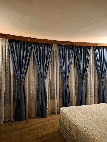 ein Schlafzimmer mit blauen Vorhängen und einem Bett in der Unterkunft The CRADLE in Daressalam