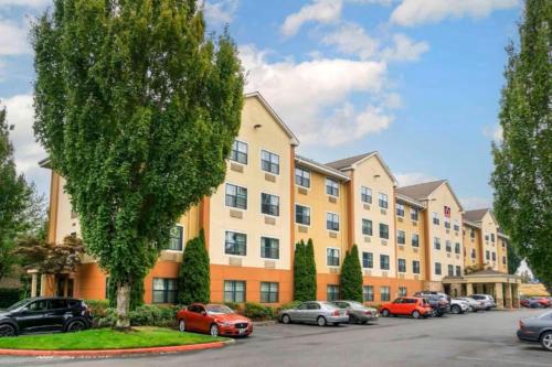 an apartment building with cars parked in a parking lot at Studio 6 Suites Seattle Kent WA in Kent