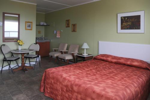 pokój hotelowy z łóżkiem, stołem i krzesłami w obiekcie Motel Bellevue w mieście Rivière-du-Loup