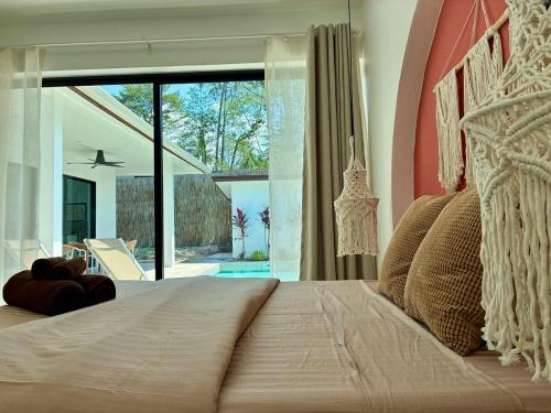 a bedroom with a large bed with a large window at Samma Villas - Ruby Villa - 2 BDR & private pool in Ko Phangan