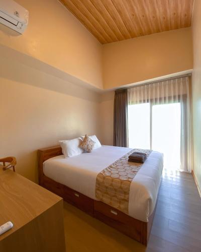 a bedroom with a large bed and a window at Los Londos Batukaras in Cijulang Nusawiru Airport