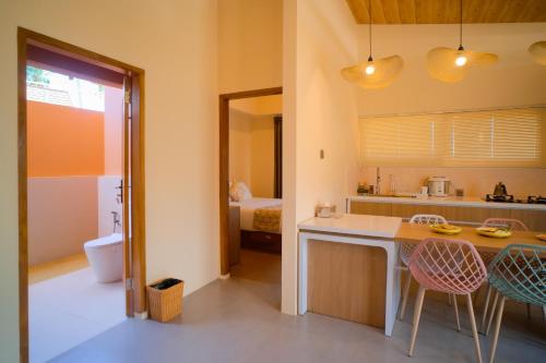 a kitchen with a counter and chairs in a room at Los Londos Batukaras in Cijulang Nusawiru Airport