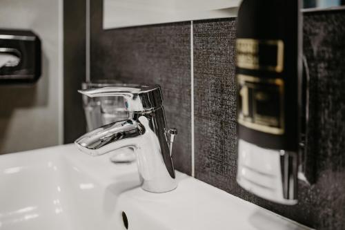 a sink with a faucet in a bathroom at Hotel Polo in Prešov