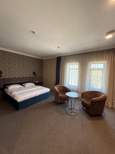 a bedroom with a bed and a table and chairs at Khan Boutique Hotel in Almaty