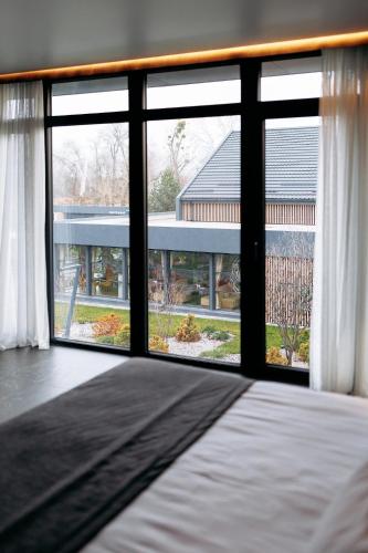 a bedroom with a large window with a view of a building at Relax Resort in Reshetilovskiy Kut